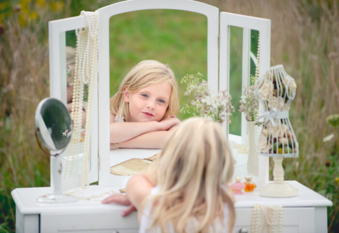 Девочка смотрит в зеркало
